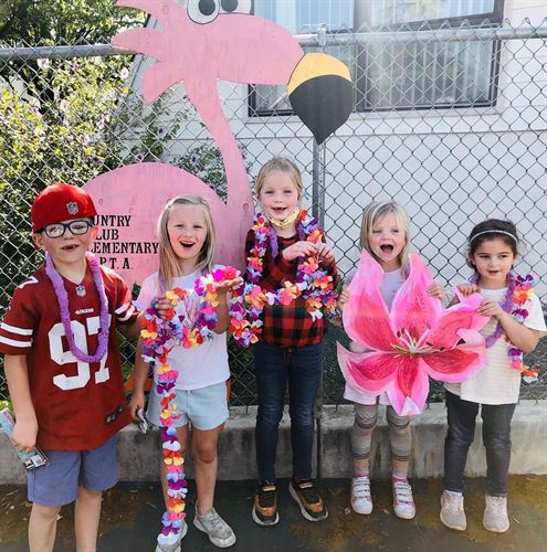 students holding pink flower decorations